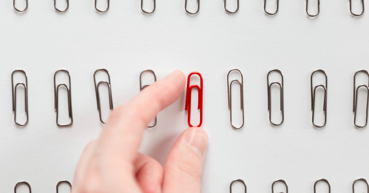 a hand reaching for a paper clip
